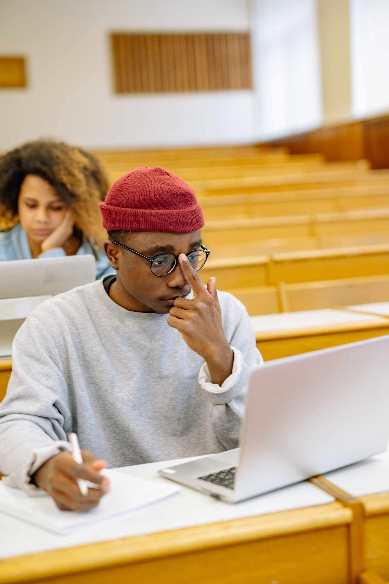 Students taking notes on laptops in a lecture hall