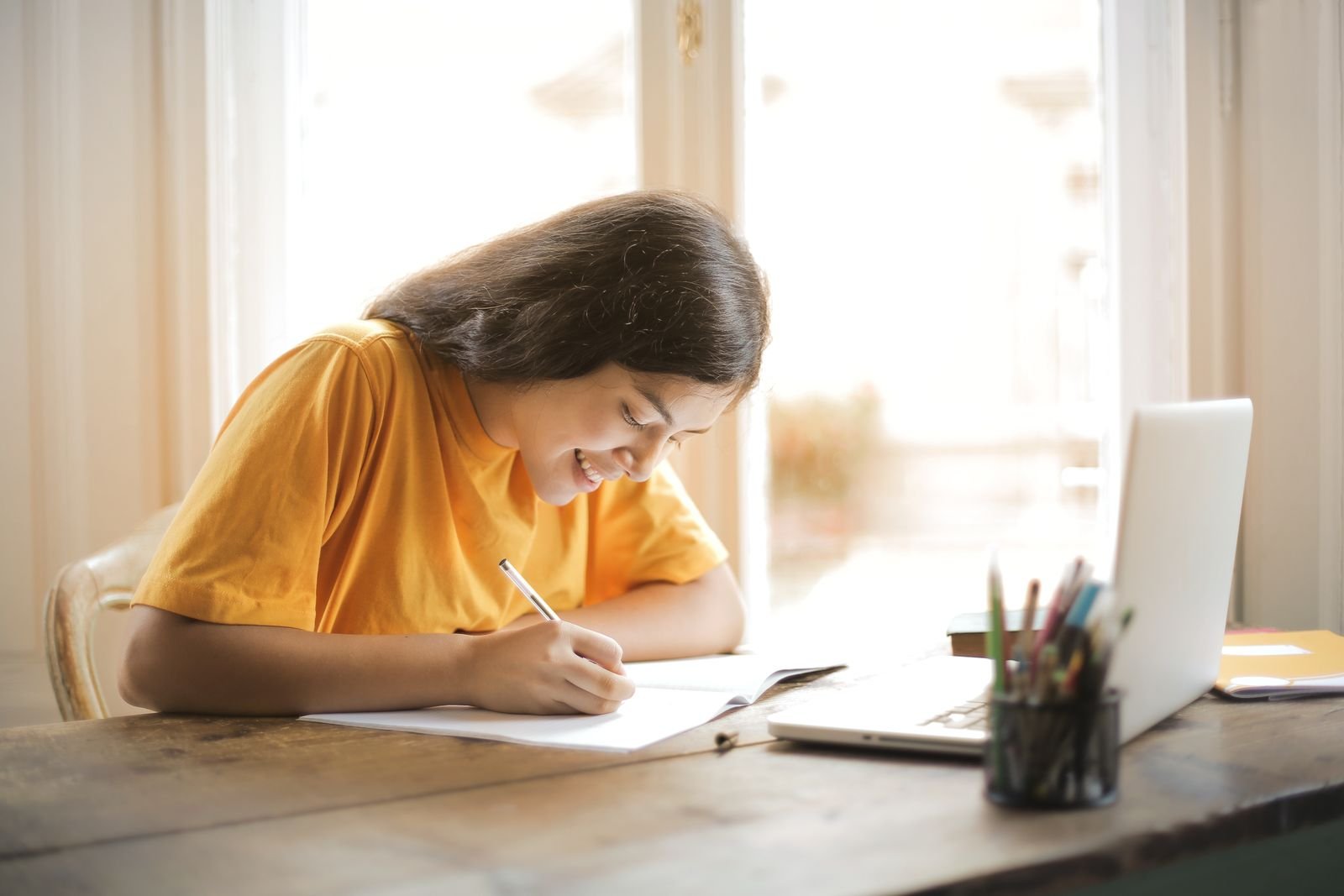 Student revising at home with a laptop and notepad