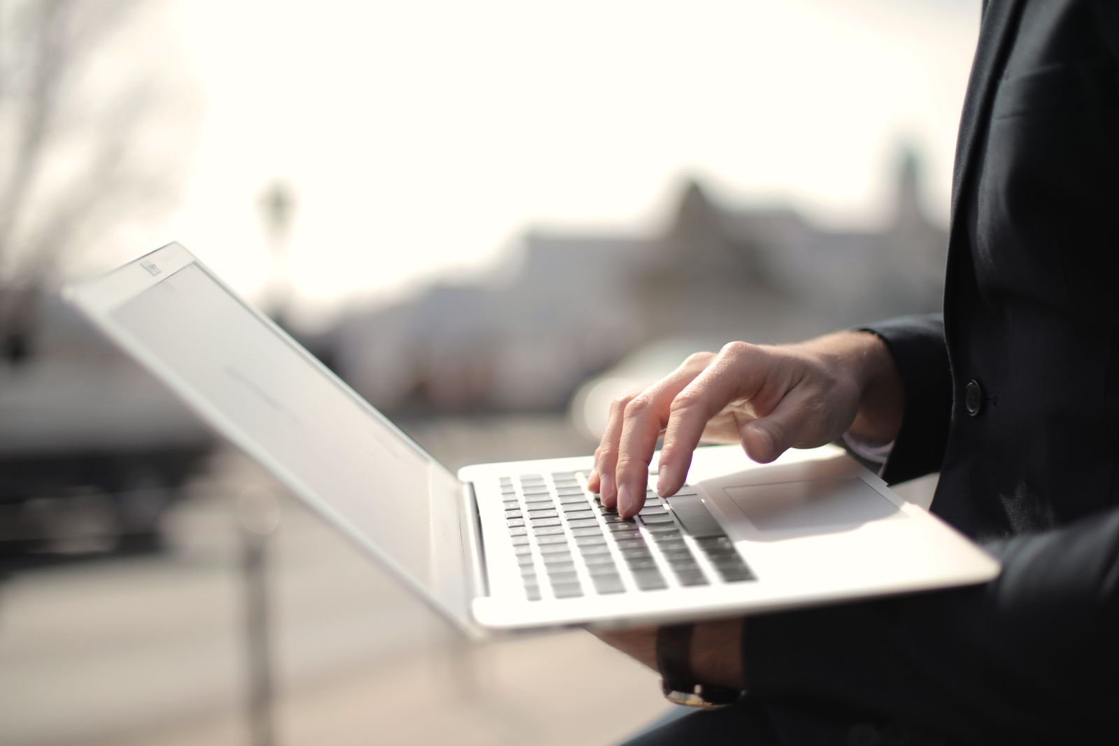 Professional typing on a laptop outdoors