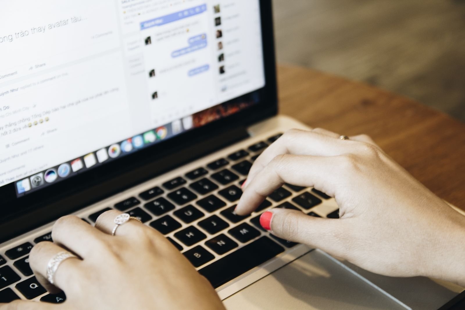 Hands typing on a laptop keyboard with a chat window open on the screen