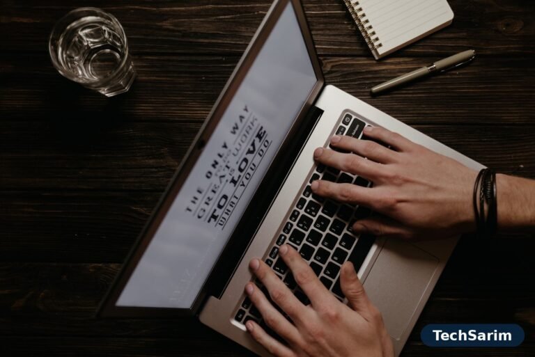 Hands on a laptop keyboard with an inspirational quote on the screen, seen from above