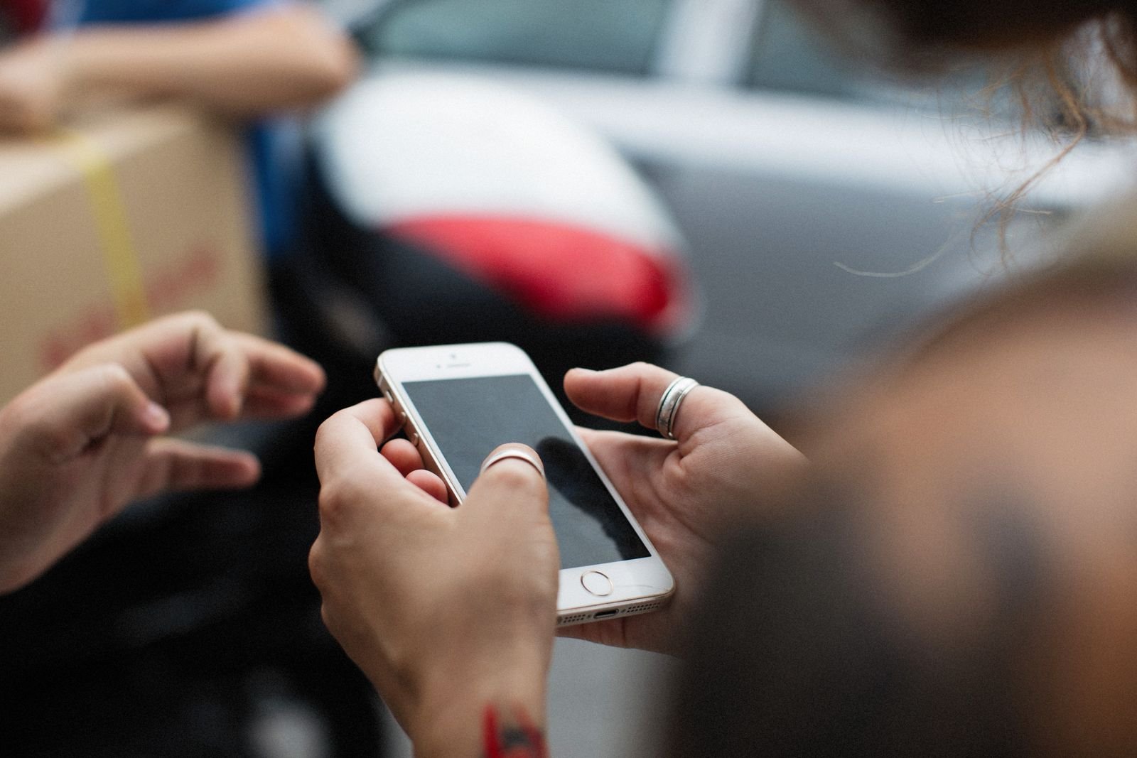Hands holding a smartphone outdoors in everyday use