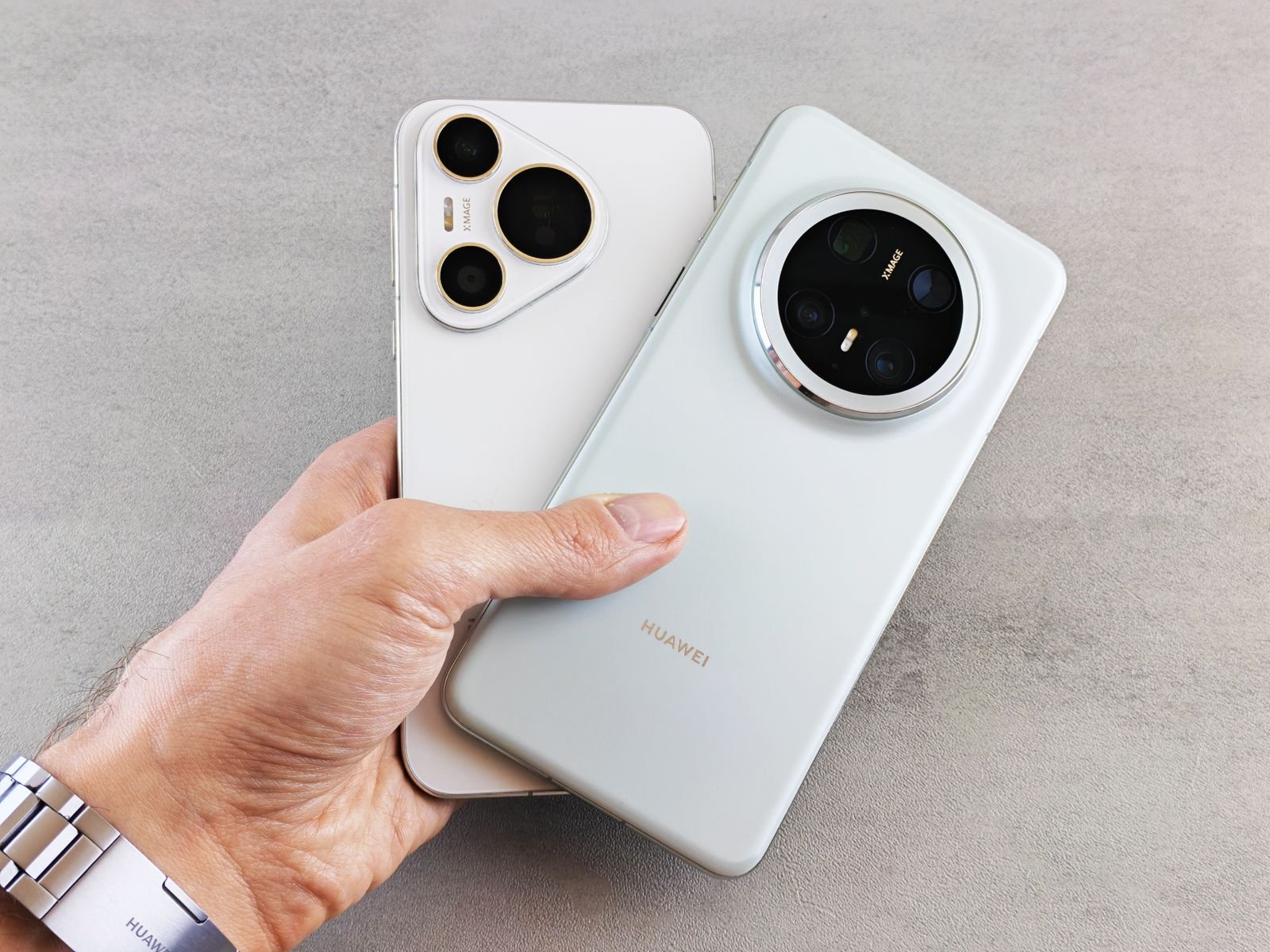 A hand holding two large-camera Android smartphones with their backs facing up