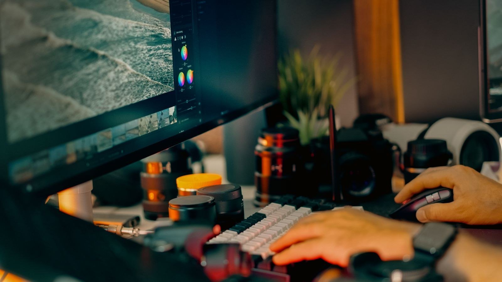 A digital photo editing workspace with a computer screen showing editing software, surrounded by camera equipment
