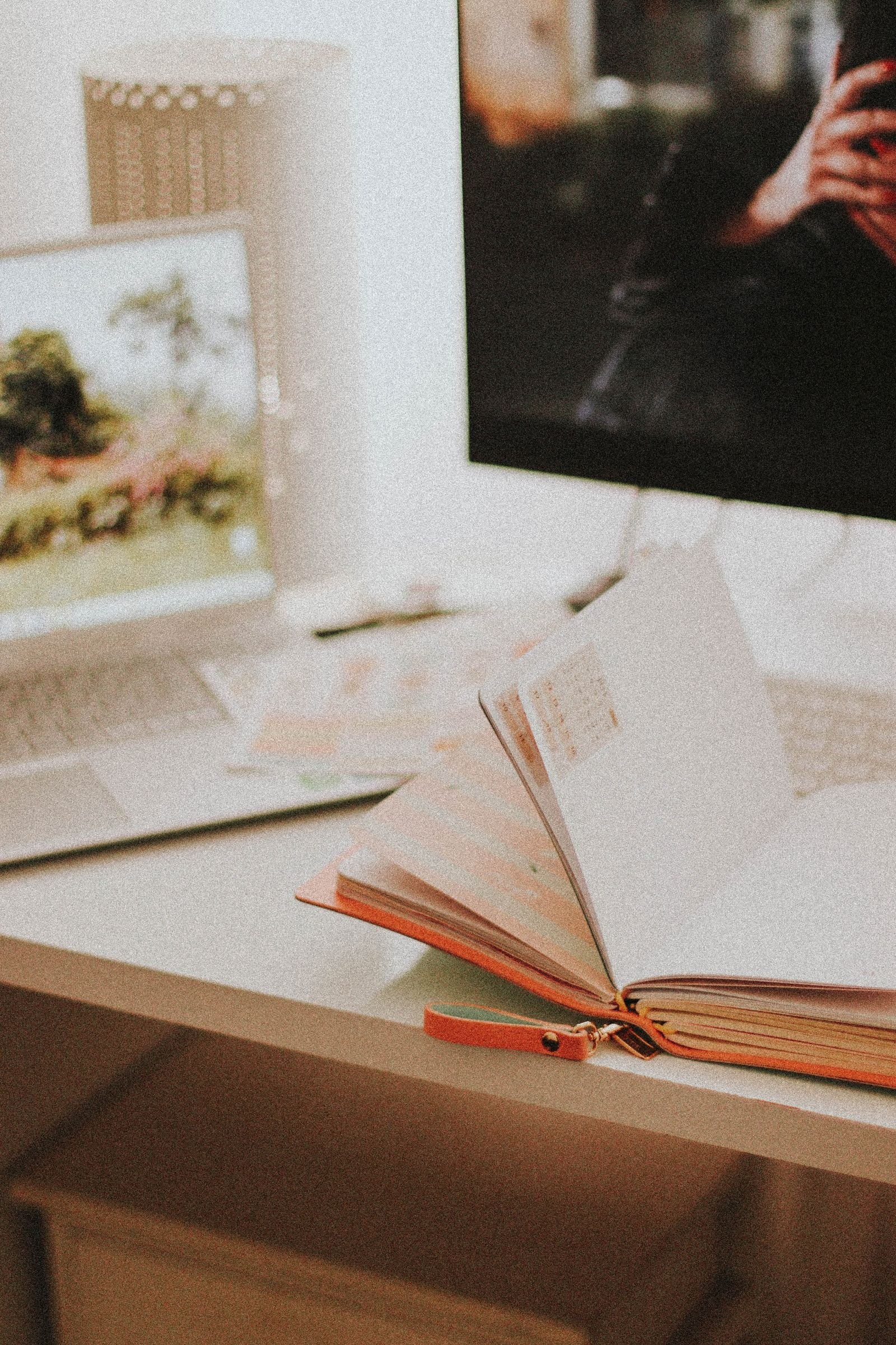 A cosy workspace with an open paper planner beside a laptop, for planning the week on paper and on screen
